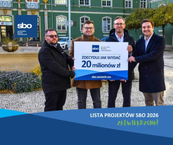 Zdjęcie przed urzędem miasta czterech mężczyzn w tym Łukasza Kadłubowskiego – zastępcy prezydenta Miasta Szczecin oraz Jakuba Baranowskiego kierownika Biura Partycypacji Społecznej, z plakatem SBO 