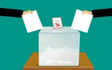 obrazek przedstawia ręce wrzucające karty do głosowania do urny 