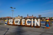 Zdjęcie przedstawia instalację wykonaną w ramach realizacji jednego z projektów SBO - biały napis "Szczecin" na Łasztowni. W tle widać katedrę oraz Zamek Książąt pomorskich
